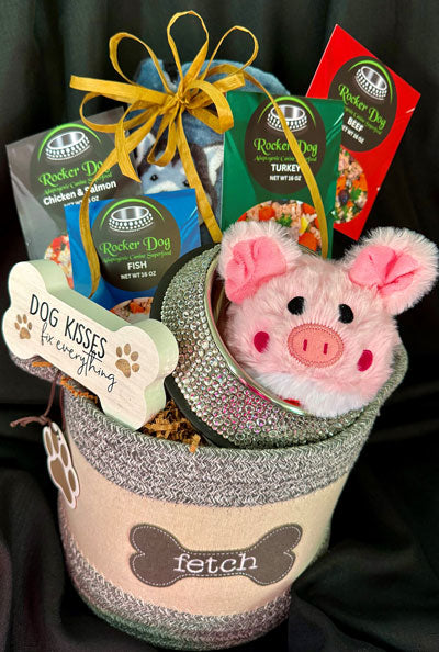 Rocker Dog Backstage Pass gift basket example consisting of a soft basket, 4 bags of Rocker Dog Adaptogenic Superfood, 1 plush pig dog toy, a dog blanket, and a rhinestone dog bowl.