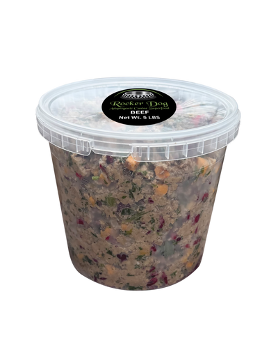 A clear 5 lb. tub of Rocker Dog's Beef dog food with visible chunks of ground beef, organic sweet potatoes, organic parsley, and organic cranberries.