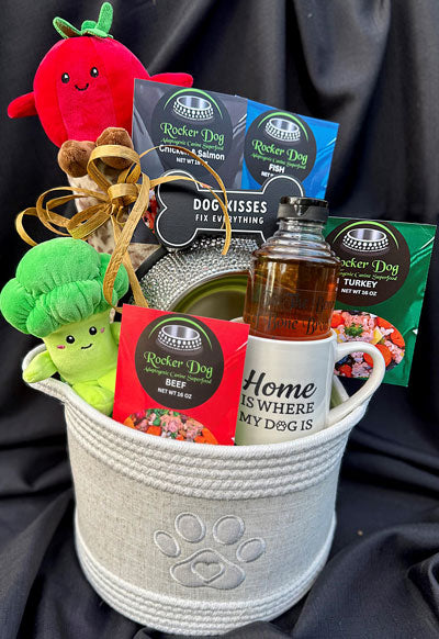 Rocker Dog All Access VIP gift basket example consisting of a soft basket, 4 bags of Rocker Dog Adaptogenic Superfood, 2 dog toys, a bottle of beef bone broth, a dog blanket, a rhinestone dog bowl, and a dog themed mug. 